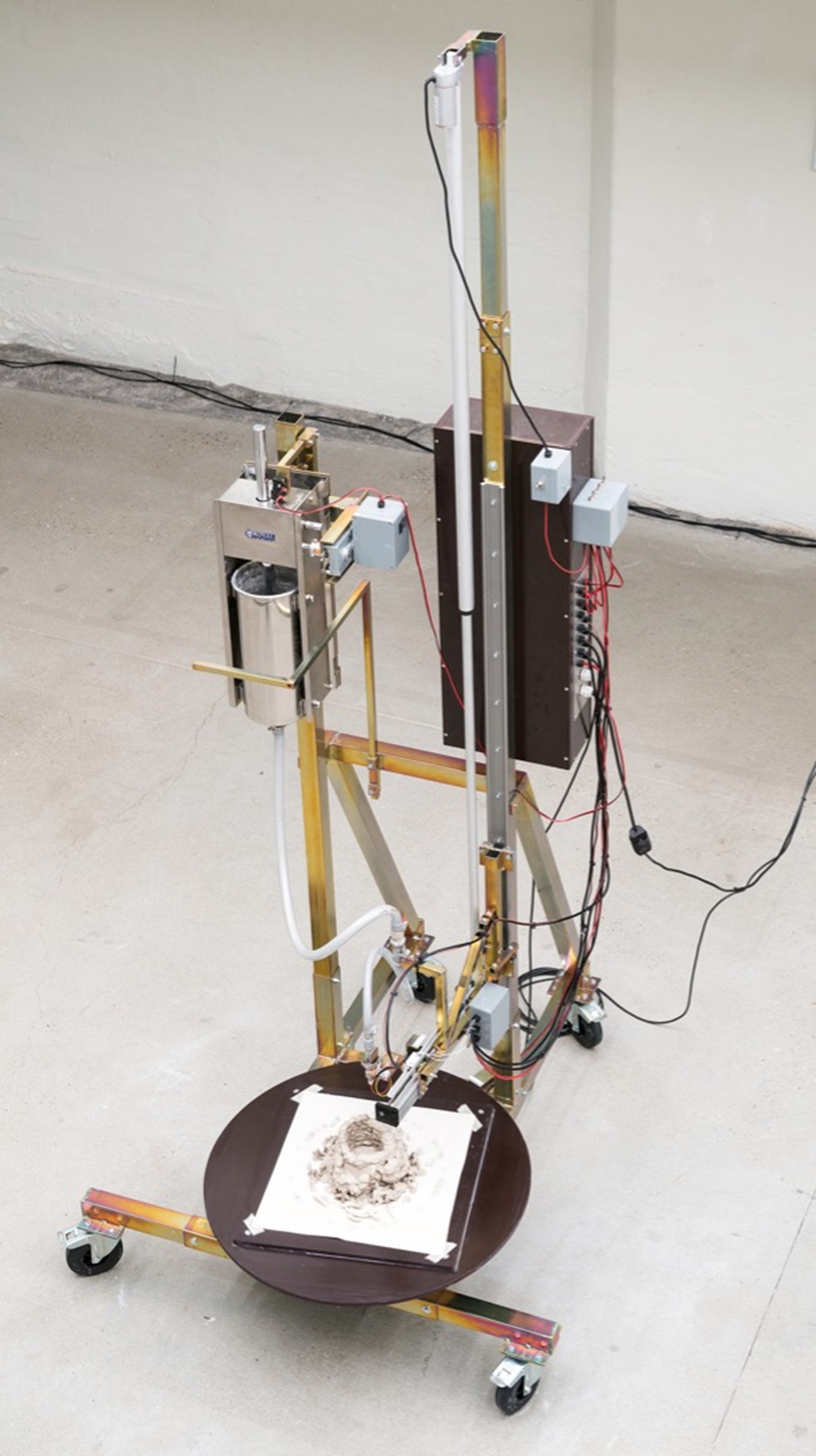 Henrik Menné: L5, 2021, iron, wood, motor, sausage press, compressed air hoses, electronics and clay, 260h x 160w x 10d cm