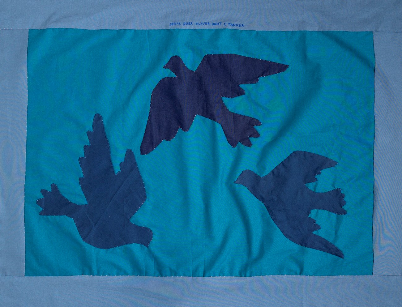 Gudrun Hasle, Sorte duer flyver runt i tanker (2022) textile and thread, 80 x 104 cm