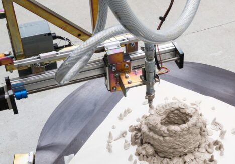Henrik Menné: L5, 2021, iron, wood, motor, sausage press, compressed air hoses, electronics and clay, 260h x 160w x 10d cm (installation view).